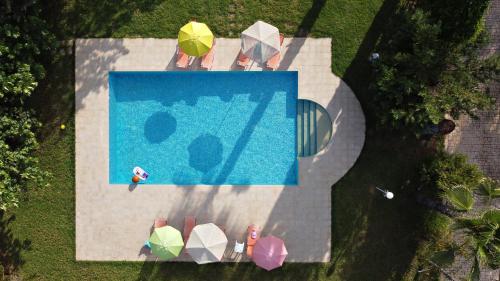 an overhead view of a swimming pool with umbrellas at Villa Vivere in Corfu Town