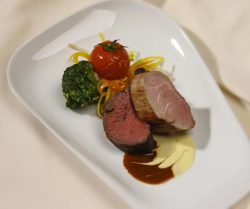 un plato de comida con carne y verduras en una mesa en Gasthof zur Grenze, en Pöttsching