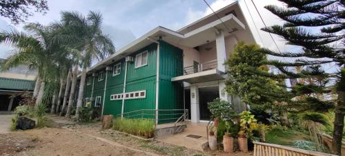 uma casa verde e branca com uma palmeira em Casa Germana em Puerto Princesa