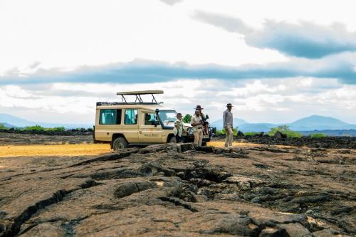 un grupo de personas de pie delante de una furgoneta en Kilaguni Serena Safari Lodge, en Tsavo