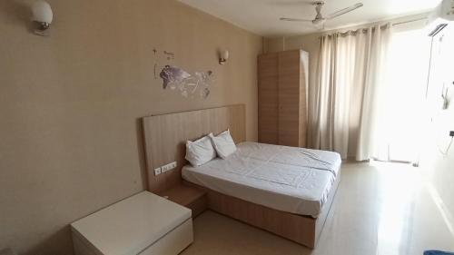 ブリンダーバンにあるAc Beautiful Luxury stay in Omaxe Vrindavan Jai bankebihariji by Shishamareの小さなベッドルーム(ベッド1台、窓付)