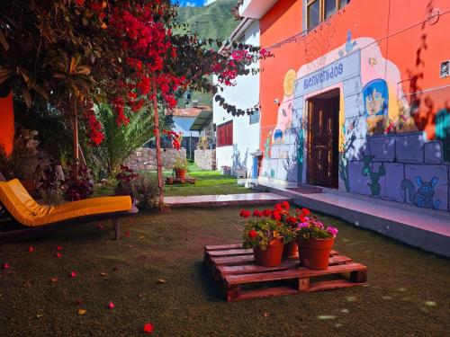 twee potbloemen op een houten platform voor een gebouw bij Valle verde, Hostel & camping in Urubamba