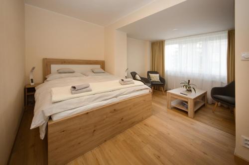 a bedroom with a large bed and a chair at Apartmán nad Ottovkou in Luhačovice