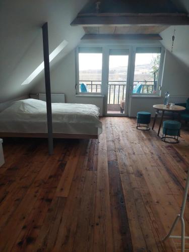 - une chambre avec un lit et du parquet dans l'établissement Slunce v duši, à Dolní Dunajovice