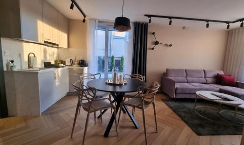 uma cozinha e uma sala de estar com mesa e cadeiras em Apartamenty przy Tężni em Busko-Zdrój