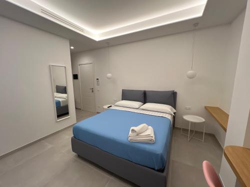 een slaapkamer met een blauw bed en een spiegel bij Elios Badino B&B in Terracina