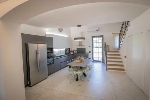 a large kitchen with a table and a refrigerator at Casa di Anna in Pistoia