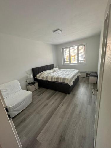 um quarto branco com 2 camas e uma janela em Soukromý byt 2+kk s balkónem a parkováním em Znojmo