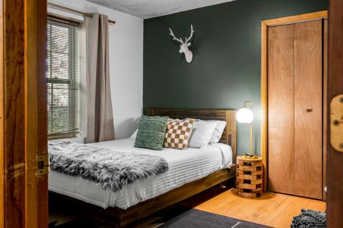 una camera da letto con un letto e pareti verdi di Escape to Sugar Chalet: The Rustic Modern Retreat a Gatlinburg