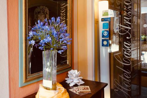 un vase de fleurs bleues assis sur une table dans l'établissement Hotel Casa Arizzoli, à Cannobio