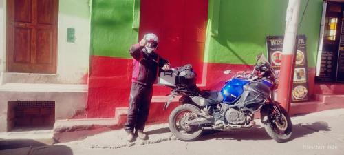 a person standing next to a motorcycle in front of a building at ANDENES DEL TITICACA in Puno