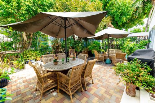 a patio with a table and chairs and an umbrella at Antigua Village Beach Resort in Saint Johnʼs