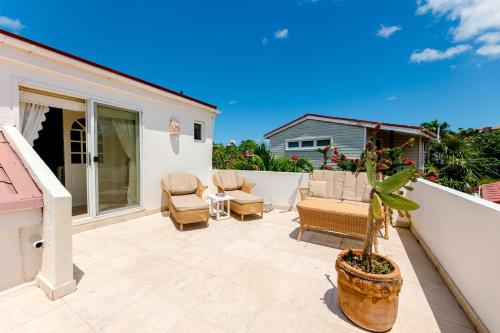 a patio with chairs and a potted plant at Antigua Village Beach Resort in Saint Johnʼs