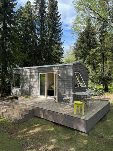 una casa pequeña con terraza y mesa en Tiny House mit Garten in der Lüneburger Heide, en Soltau