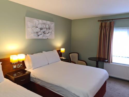 um quarto de hotel com duas camas e uma janela em Killarney Court Hotel em Killarney