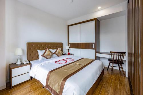 um quarto com uma cama grande e uma mesa em Phong Lan Apartments em Hai Phong