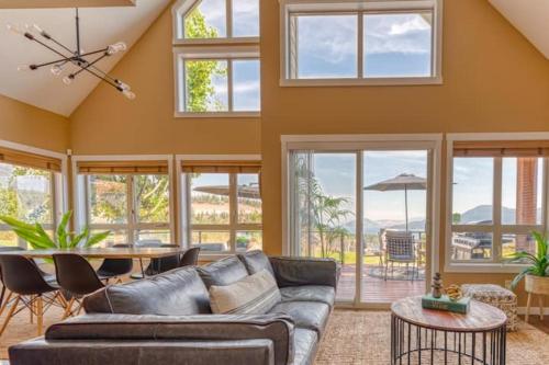 een woonkamer met een bank en een tafel bij Exceptional Cozy Cottage with Incredible View! in Kelowna