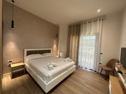 una camera da letto con un grande letto bianco e una finestra di Arial Trinity Suites a Vlorë