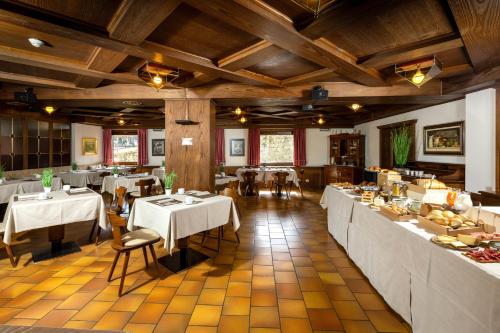 un restaurant avec des tables et des chaises et un buffet dans l'établissement Hotel Cardo, à Valdidentro