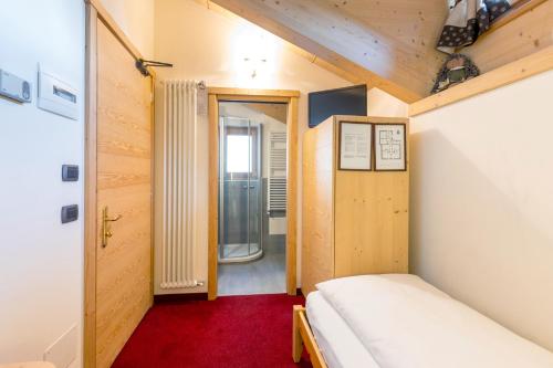 - une petite chambre avec 2 lits et un tapis rouge dans l'établissement Hotel Cardo, à Valdidentro