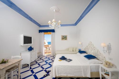 um quarto com uma cama, uma secretária e uma televisão em Villa Flavio Gioia em Positano