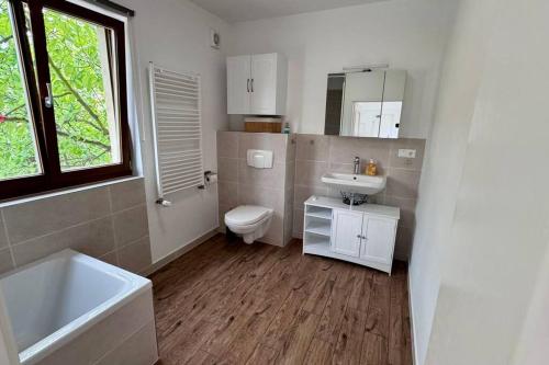 La salle de bains est pourvue d'un lavabo, de toilettes et d'une baignoire. dans l'établissement Design Apartment im alten Schloss Deidesheim, à Deidesheim