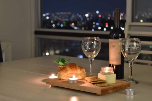 a table with wine glasses and a loaf of bread and candles at Penthouse Espectacular Vista Cd A.C. WiFi 300mbps in Guadalajara