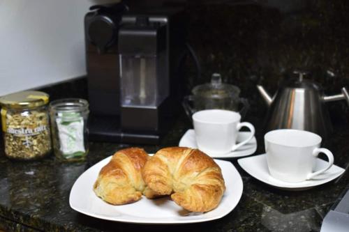 two croissants and two cups of coffee on a counter at Penthouse Espectacular Vista Cd A.C. WiFi 300mbps in Guadalajara