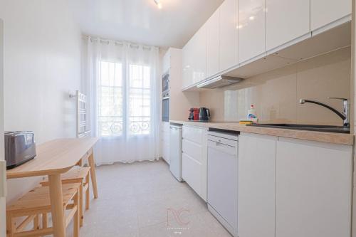 een keuken met witte kasten en een houten tafel bij *Disneyland-Paris*4pers, Wifi, Parking in Serris