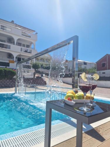 - une table avec un verre de vin à côté de la piscine dans l'établissement Apartments Silva with a view of sea, à Trogir