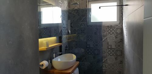 a bathroom with a white sink and a window at Apartments Perina in Tisno