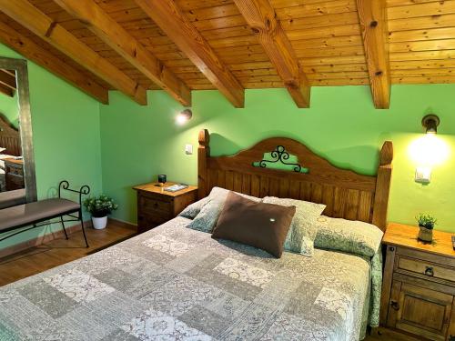 ein Schlafzimmer mit einem Bett und einer grünen Wand in der Unterkunft Apartamentos Rurales Las Dos Torres in Isla