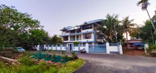 una casa con una valla azul frente a una calle en Captains Cabin backwater resort, en Alleppey