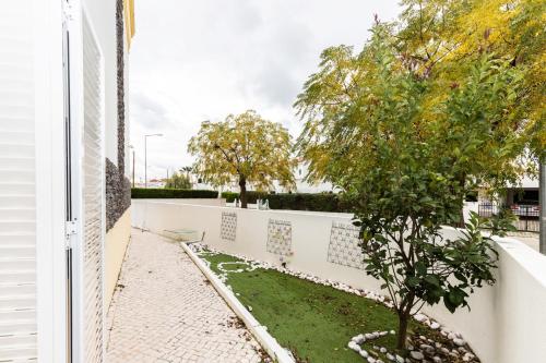 Ein weißer Zaun mit einem Baum im Hof. in der Unterkunft Villa Mar by ALGARVEMANTA in Manta Rota