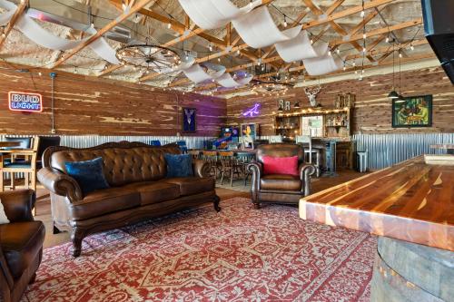 a living room with leather furniture and a bar at Roadrunner Inn and Log Cabins in Eureka Springs