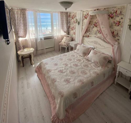 een slaapkamer met een roze bed met een baldakijn bij Shalanda in Odessa