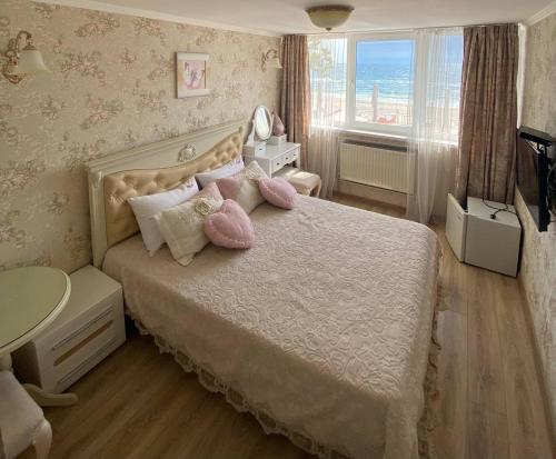 een slaapkamer met een bed met roze kussens en een raam bij Shalanda in Odessa