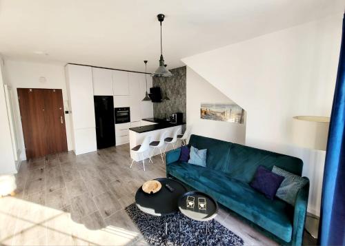 sala de estar con sofá verde y cocina en Apartament nad Jeziorem, en Olecko