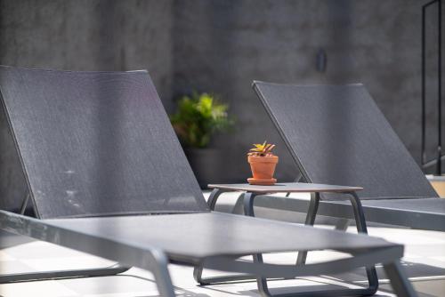 zwei Stühle neben einem Tisch mit Topfpflanze in der Unterkunft Studios by Aqua Natura Hotels in Porto Moniz