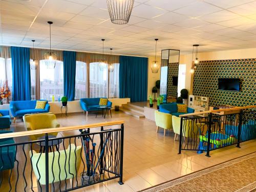 eine Lobby mit einem Wartezimmer mit blauen und gelben Stühlen in der Unterkunft Flóra Panzió in Miskolctapolca