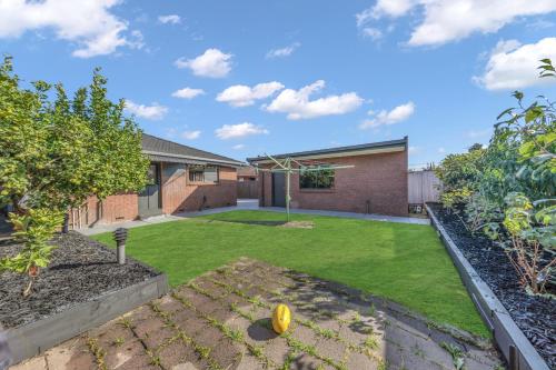 a backyard with a lawn and a house at Newly Renovated House near Melbourne Airport in Melbourne