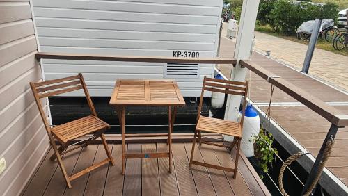 2 sedie e un tavolo in legno su una terrazza di Floating house - Marina Relax a Portoroz