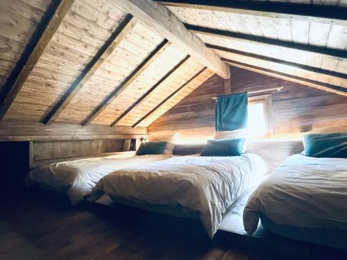 Duas camas num quarto com paredes de madeira em Le Chalet Georges em Chamonix-Mont-Blanc