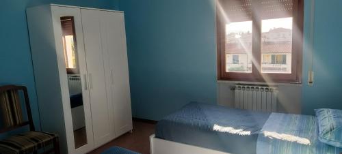 een blauwe slaapkamer met een bed en een raam bij Gian maria Vacanze in Altopascio