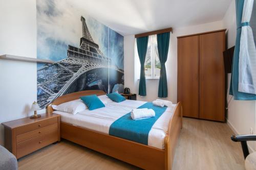 um quarto com uma cama com um quadro da Torre Eiffel em Bed and Breakfast Palac em Baška Voda