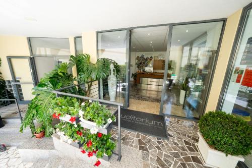 um lobby com plantas em vasos em um edifício em Hotel Auditorium em Bari