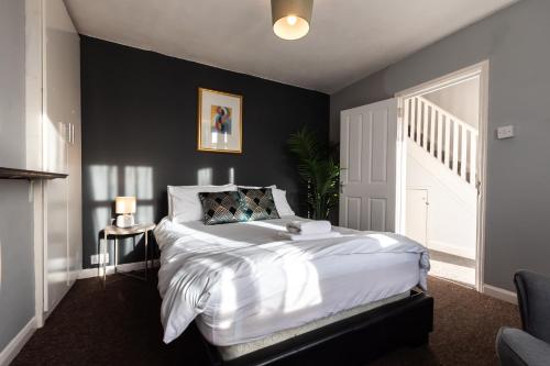 a bedroom with a large bed with a black wall at 4 bedrooms house for working Professionals in Southampton