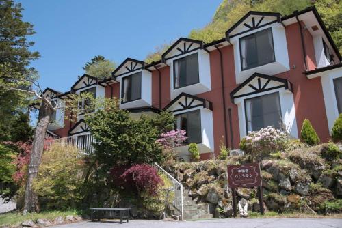 uma casa grande com um sinal em frente em Chuzenji Pension em Nikko