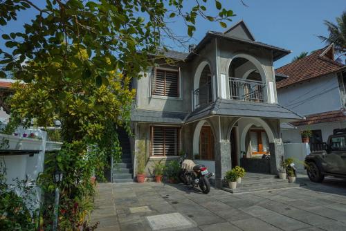 una casa con una moto parcheggiata di fronte di Mickey Homestay a Thekkady