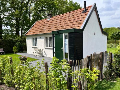 een klein wit huis met een groene deur bij De Egelburcht in Garderen